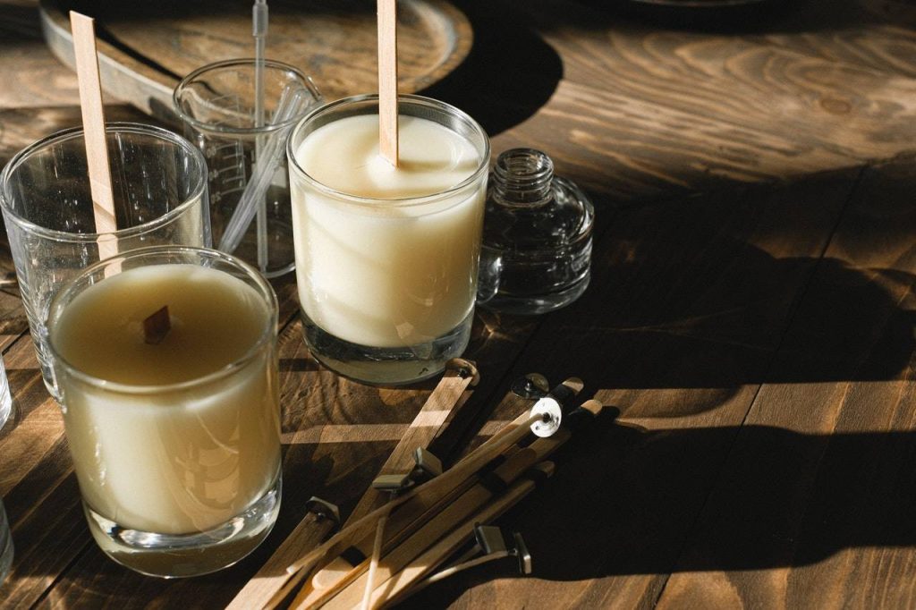 Glasses with organic candles on wooden table - Dato Darren Yaw