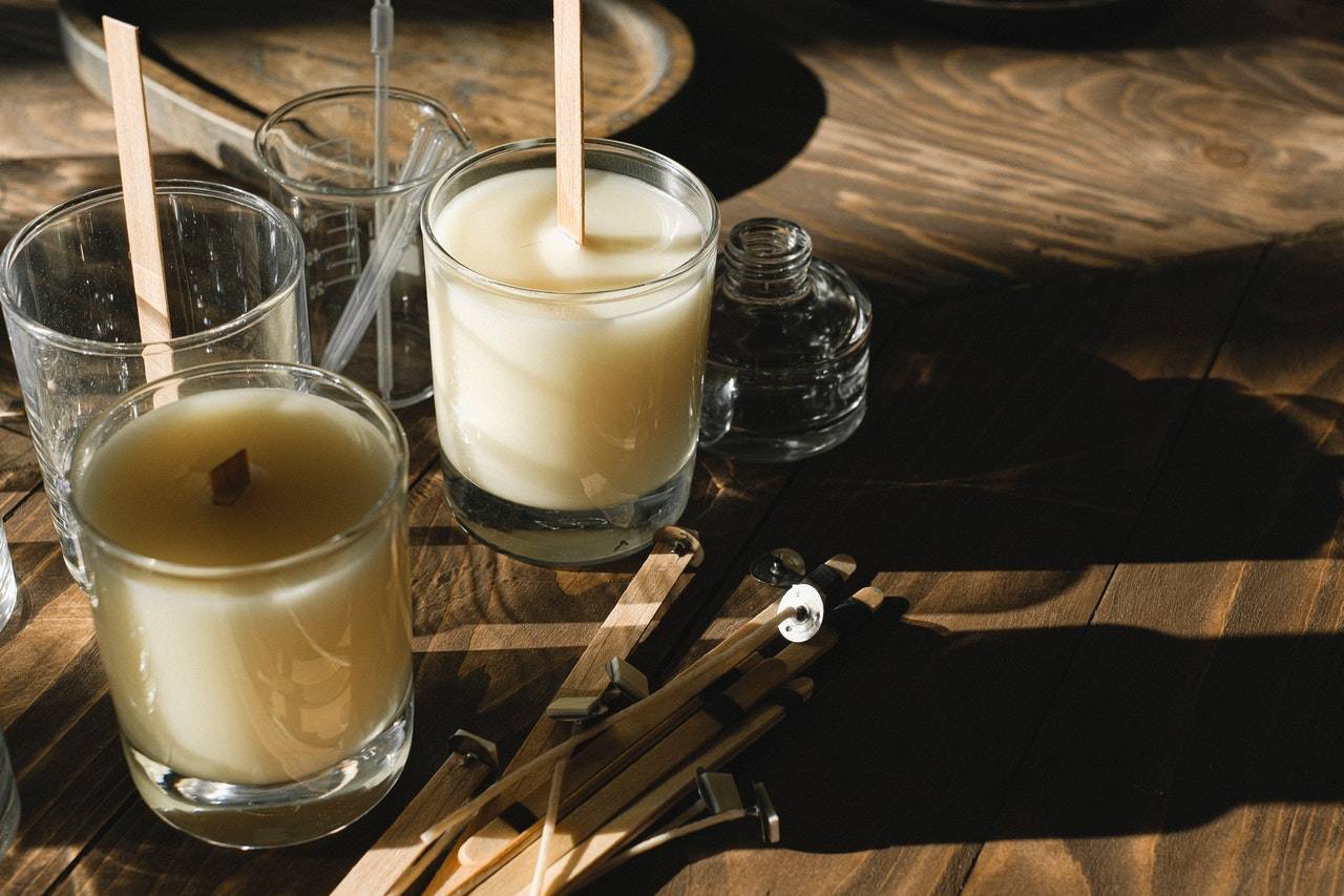 Glasses with organic candles on wooden table - Dato Darren Yaw